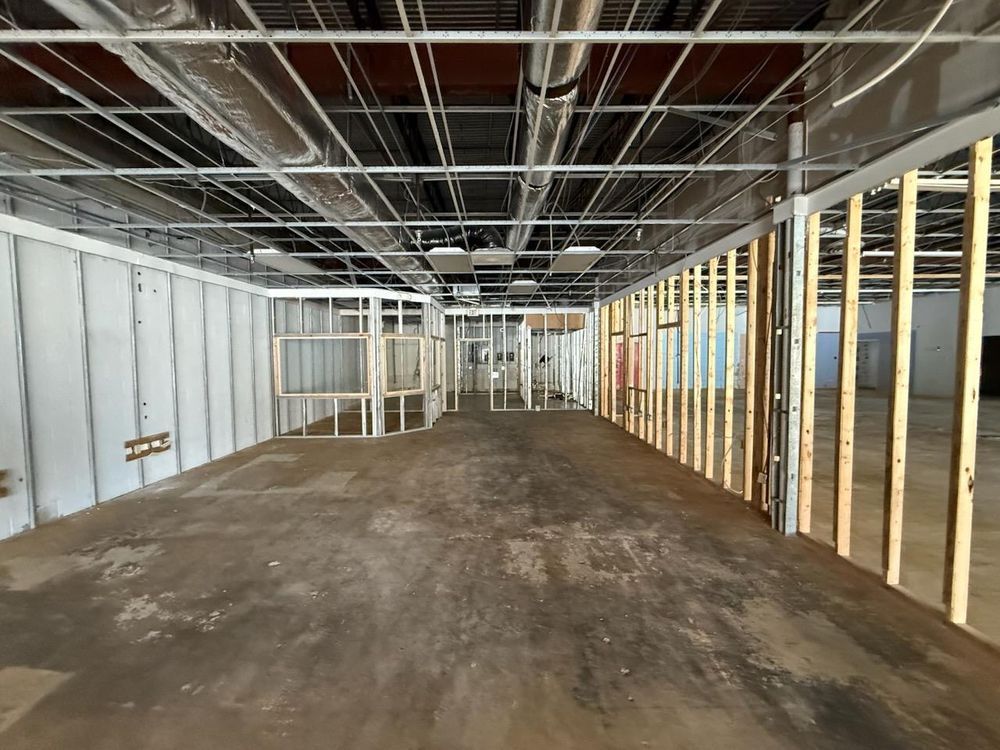 Empty unfinished interior with exposed ceiling, framing, and concrete floor under construction