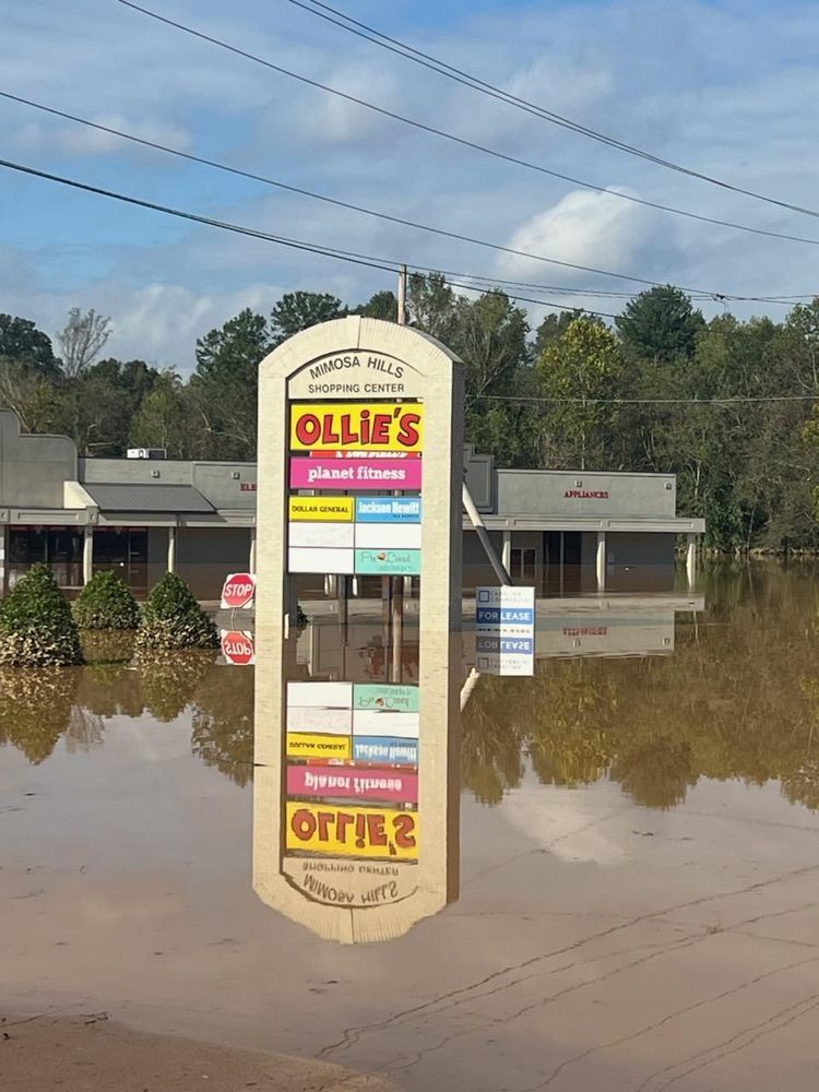 Flooded street with an Ollie's store sign standing in standing water.