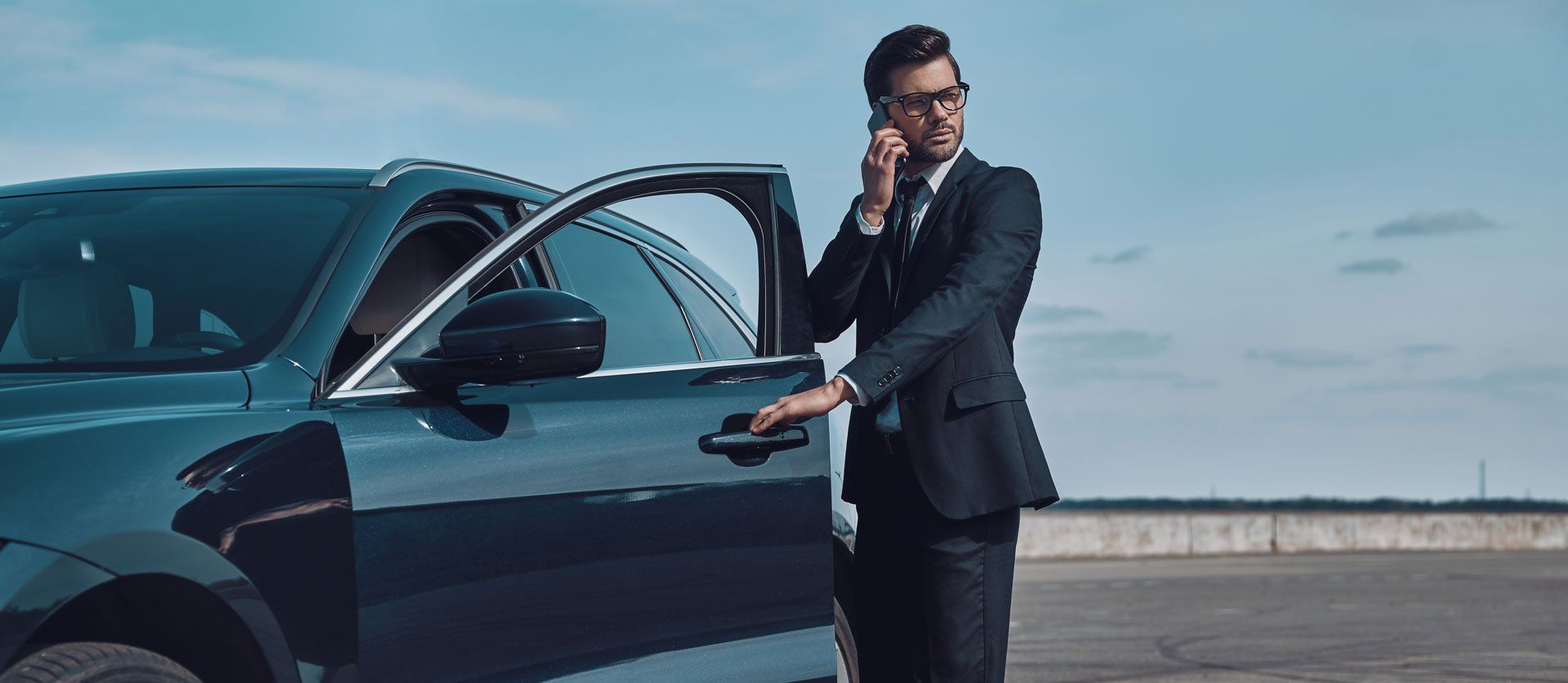 man standing near a luxury car