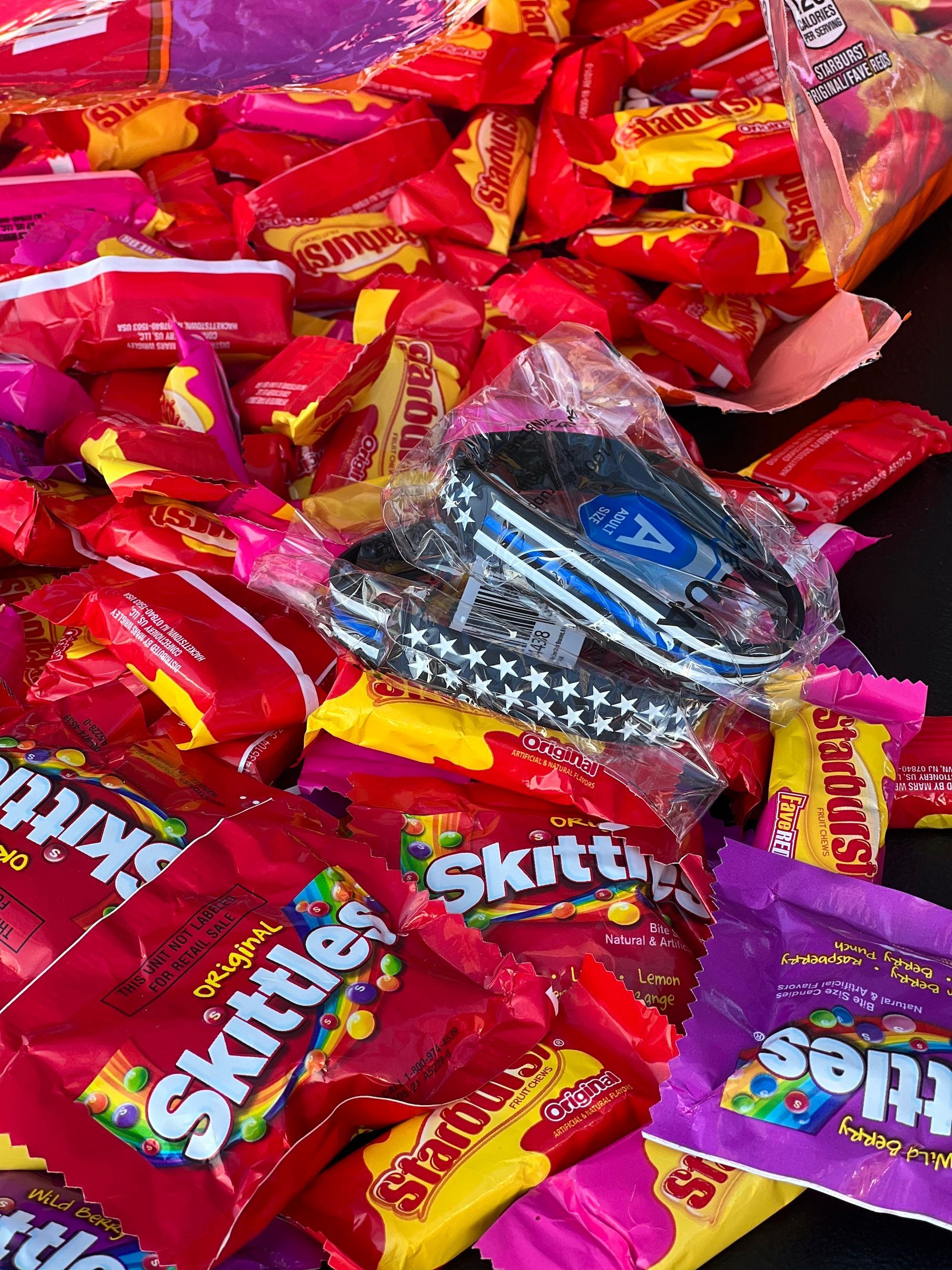 A pile of skittles and bracelets on a table