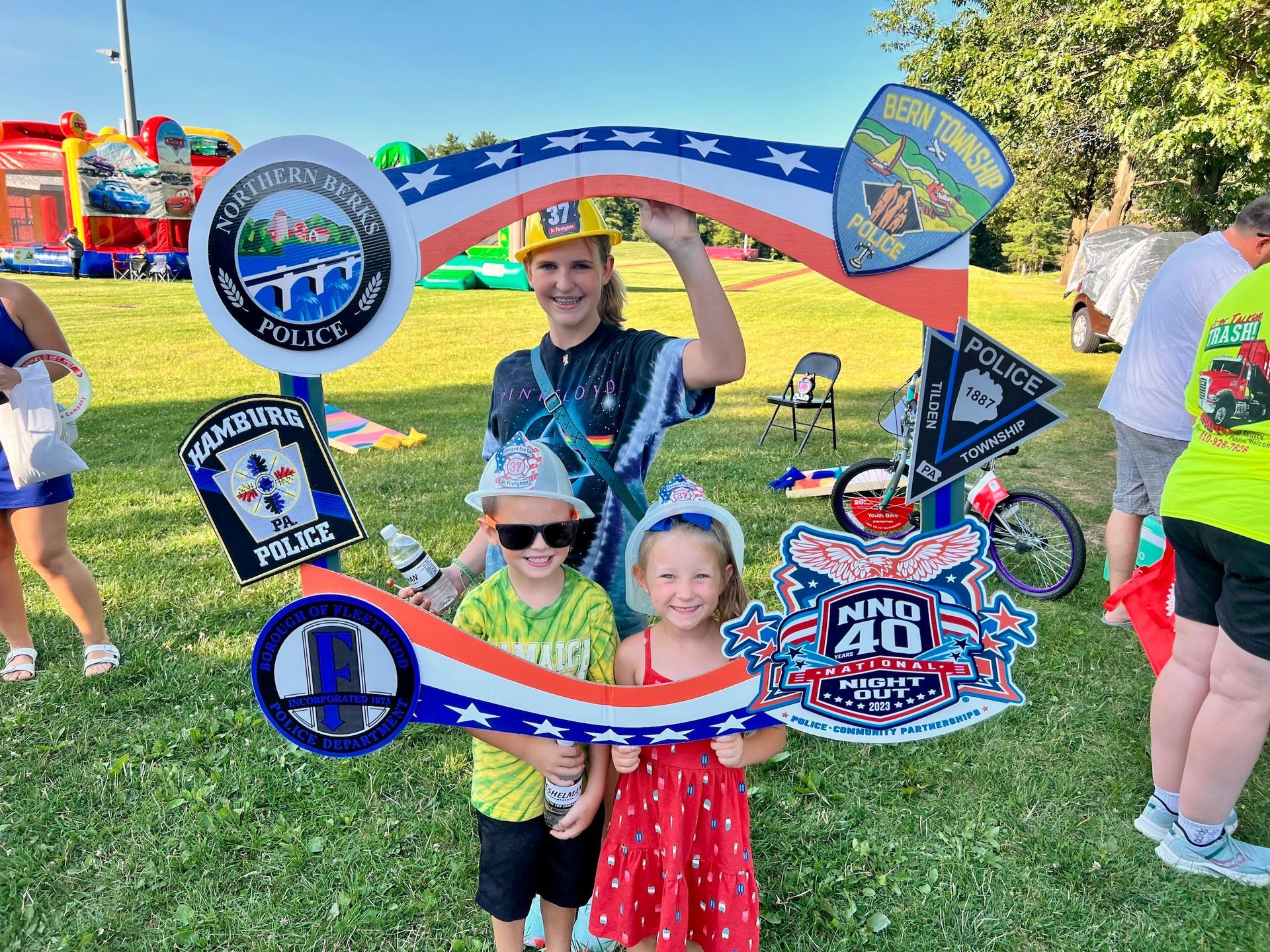 A woman and two children are posing for a picture in a park.