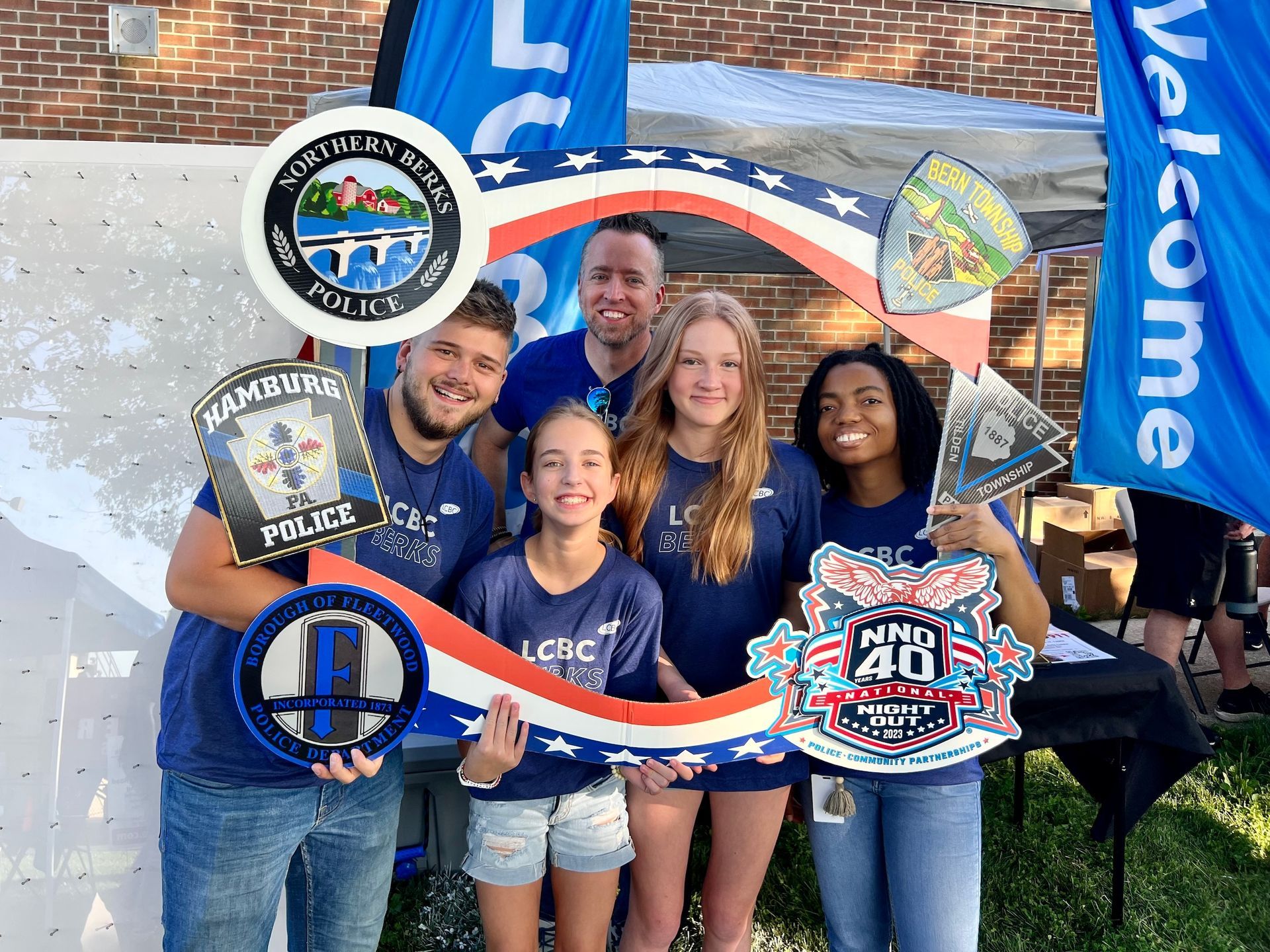 A group of people are posing for a picture with a sign that looks like a key.