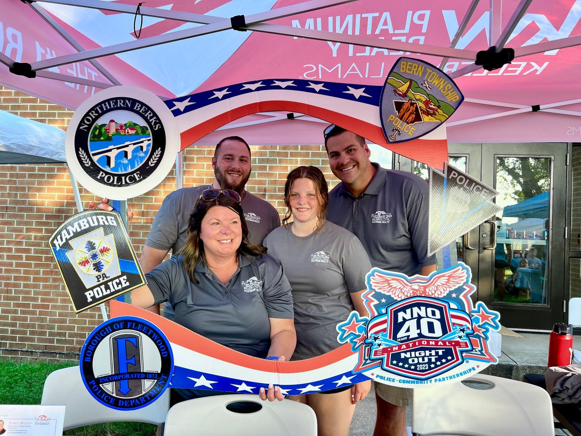 A group of people are posing for a picture in front of a tent.