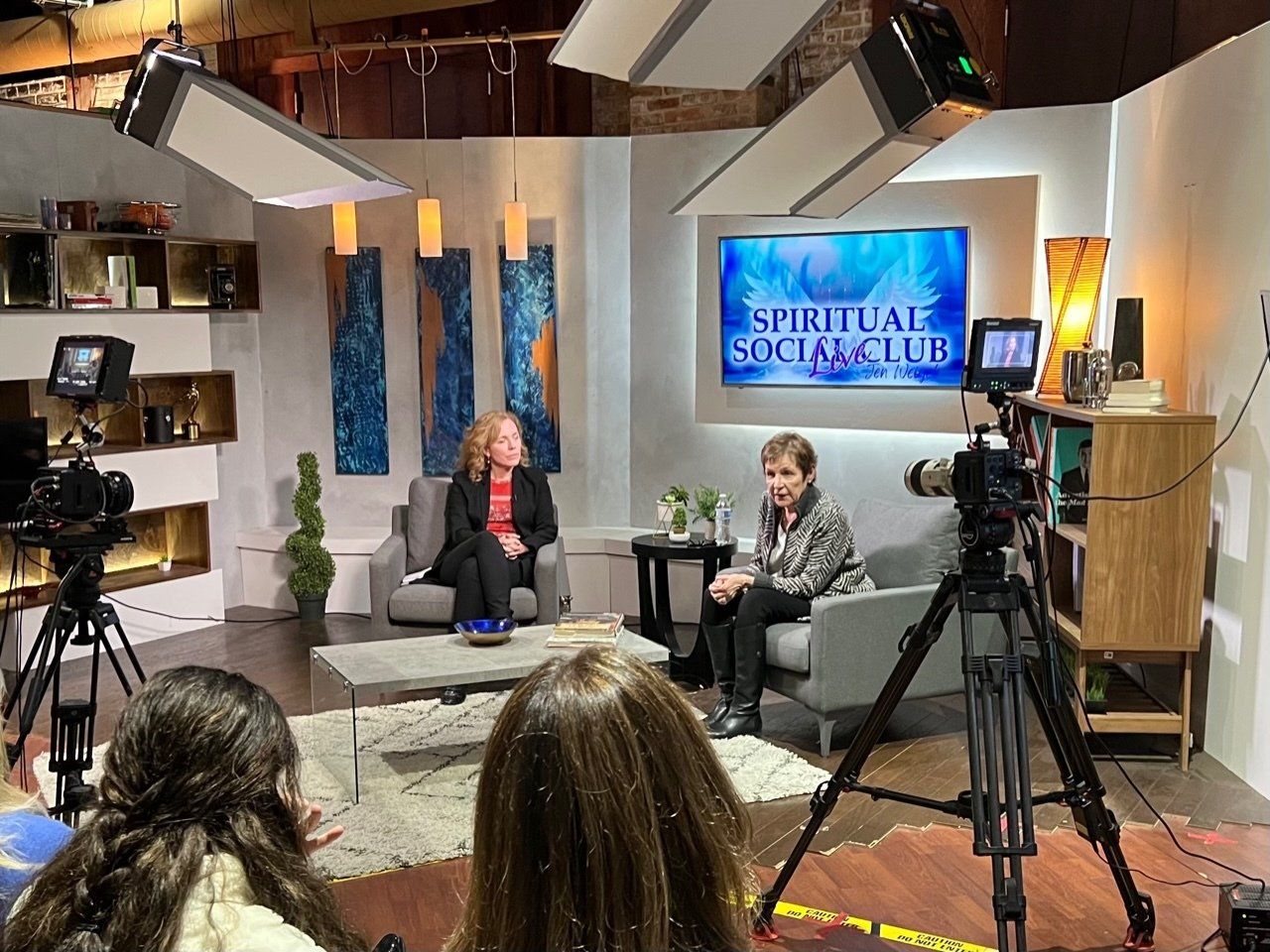 A group of people are sitting in front of a camera in a studio.
