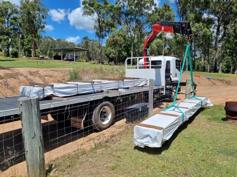 A Truck With a Crane on the Back of It is Carrying a Large Piece of Wood — BS Crane Truck and Trailer Hire In Yandina, QLD