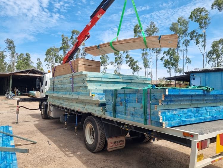 A Crane is Lifting a Piece of Wood From a Truck — BS Crane Truck and Trailer Hire In Gympie, QLD
