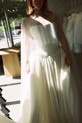 A man is working on a wedding dress in a studio.