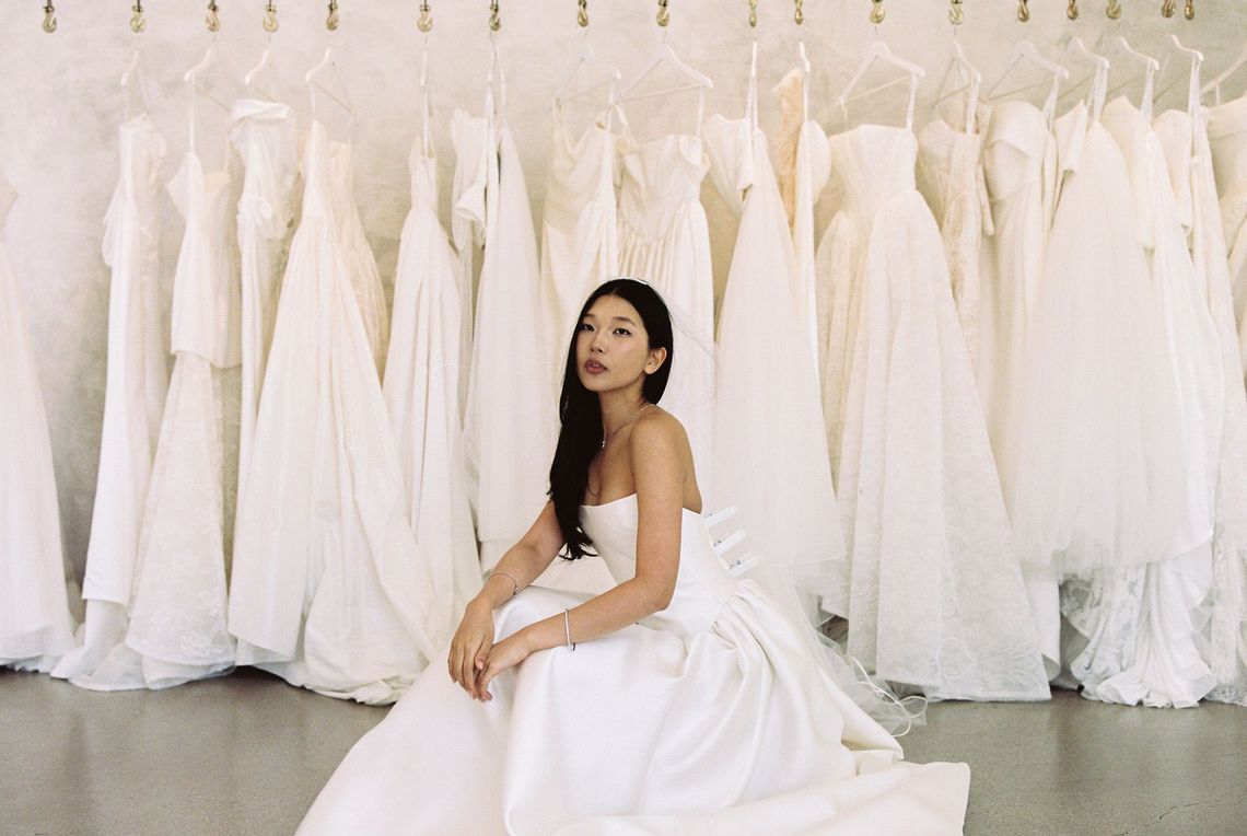 A woman in a wedding dress is sitting on a couch.