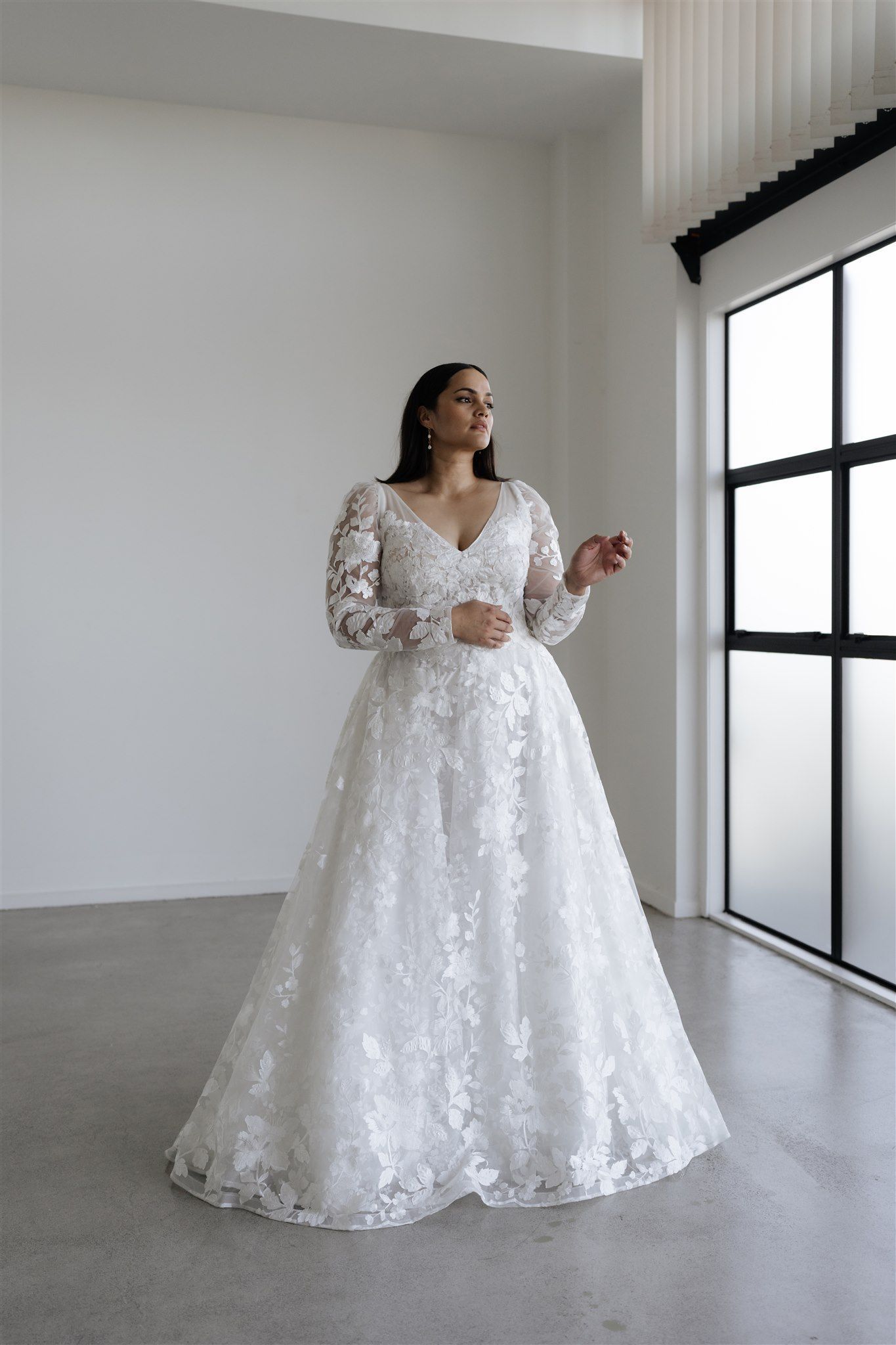Intricate wedding gown with long sleeves and floral lace overlay