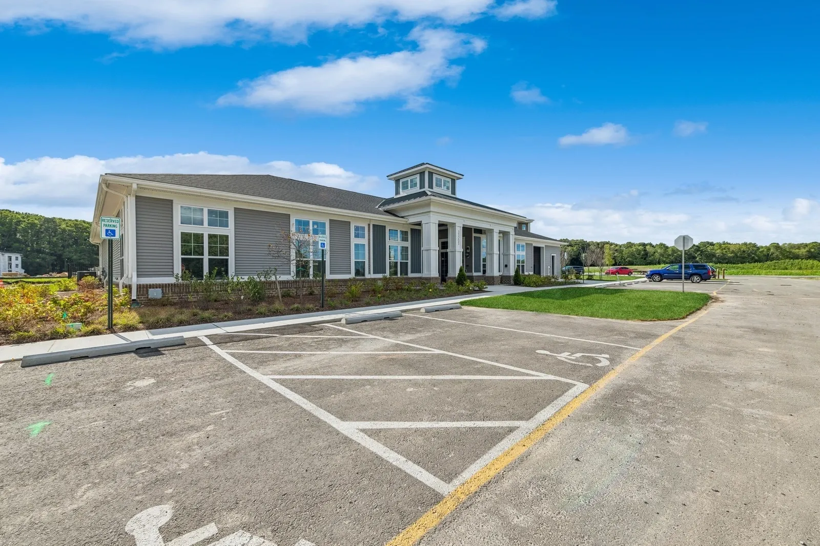 Exterior view of a modern apartment building with handicap parking and a spacious lot.