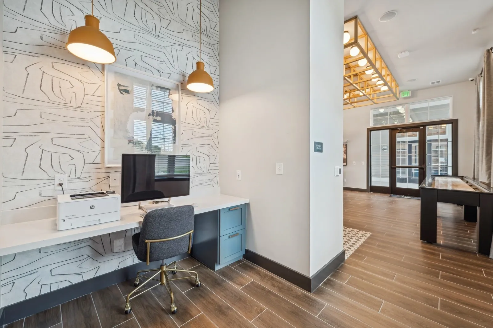 Leasing desk with computer and printer in a modern community lobby.