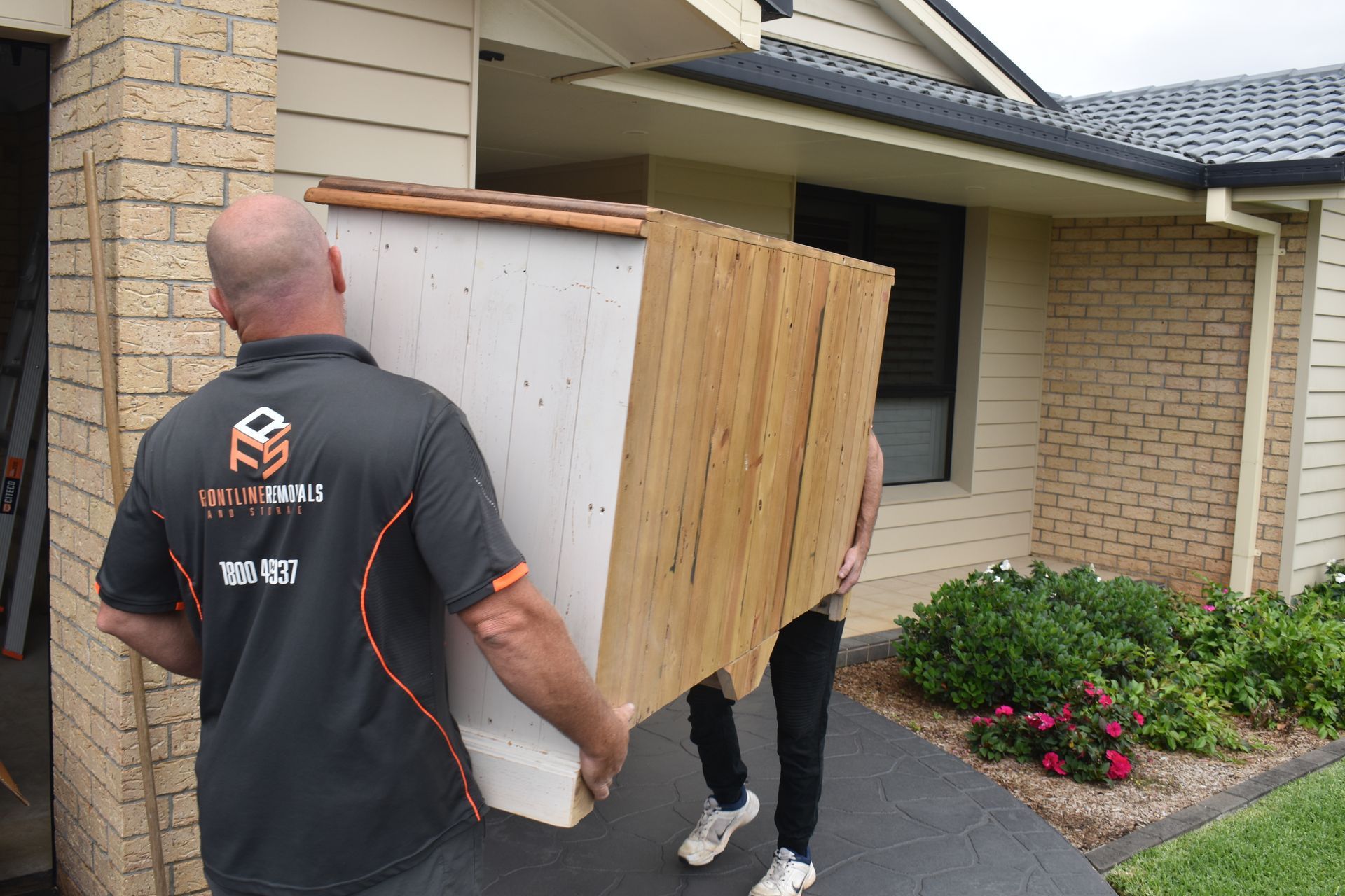 A Man And A Woman Are Standing Next To A Fragile Cardboard Box — Frontline Removals And Storage in South West Rocks, NSW
