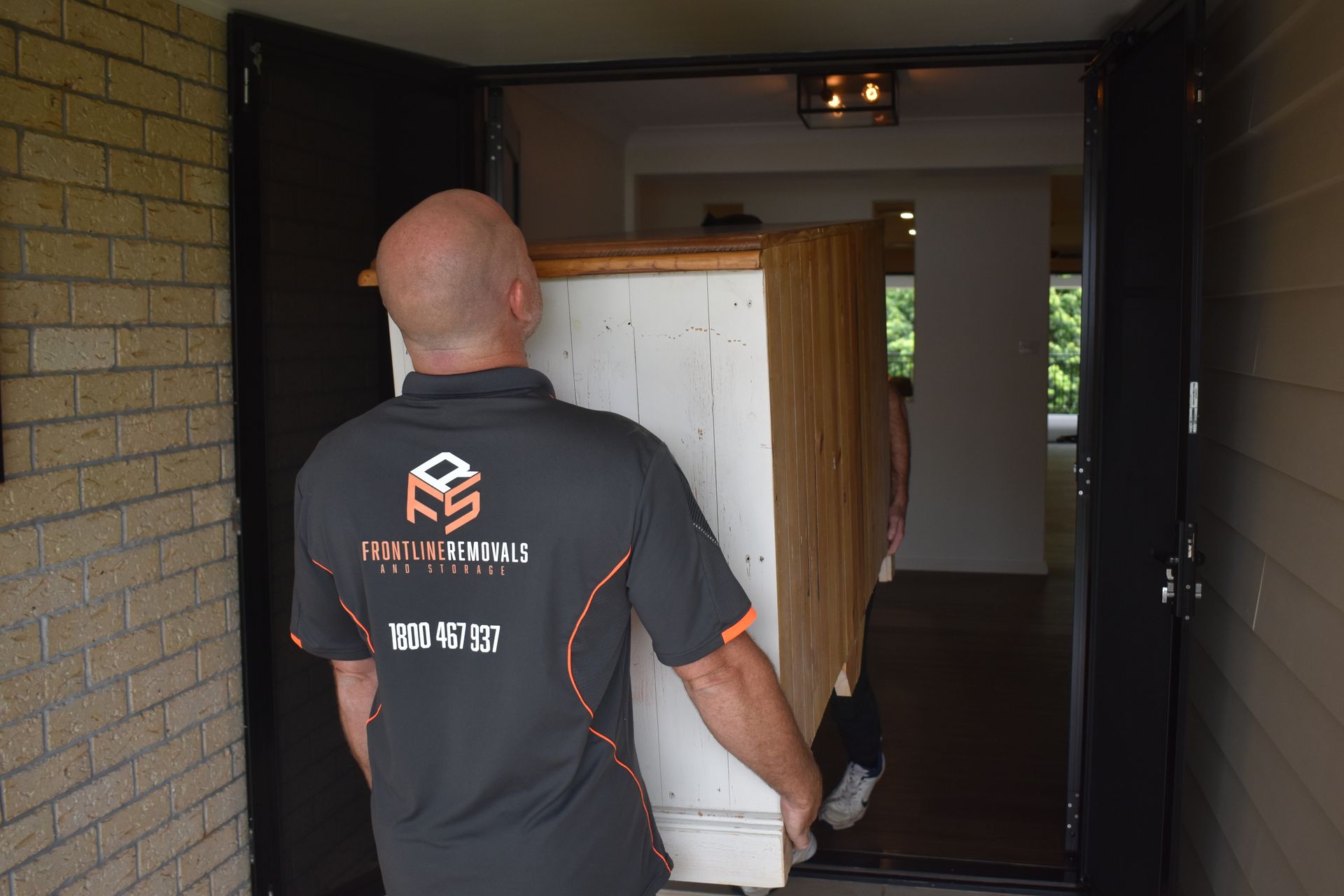 A Woman Wearing A Hard Rock Cafe Sweatshirt Is Wrapping A Box — Frontline Removals And Storage in Sydney, NSW