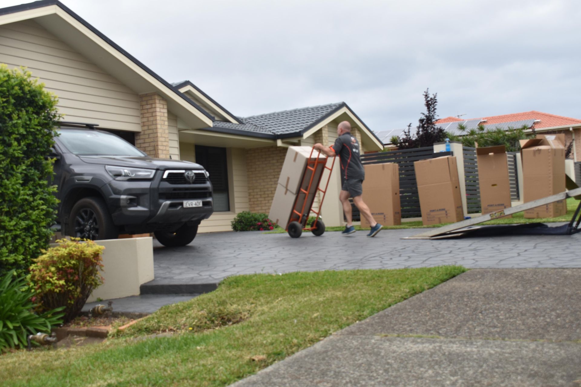 Man Moving Boxes With a Dolly Into a Truck — Frontline Removals And Storage in Port Macquarie, NSW