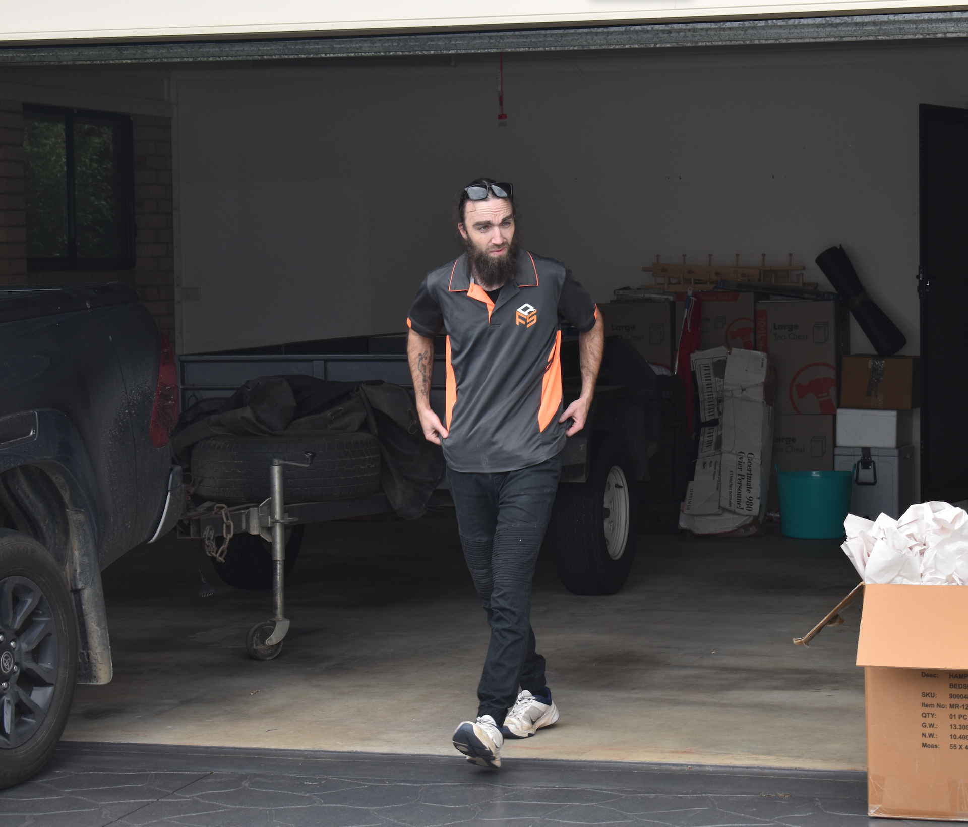 A Bearded Man Walking Out Of A Garage — Frontline Removals And Storage in Port Macquarie, NSW