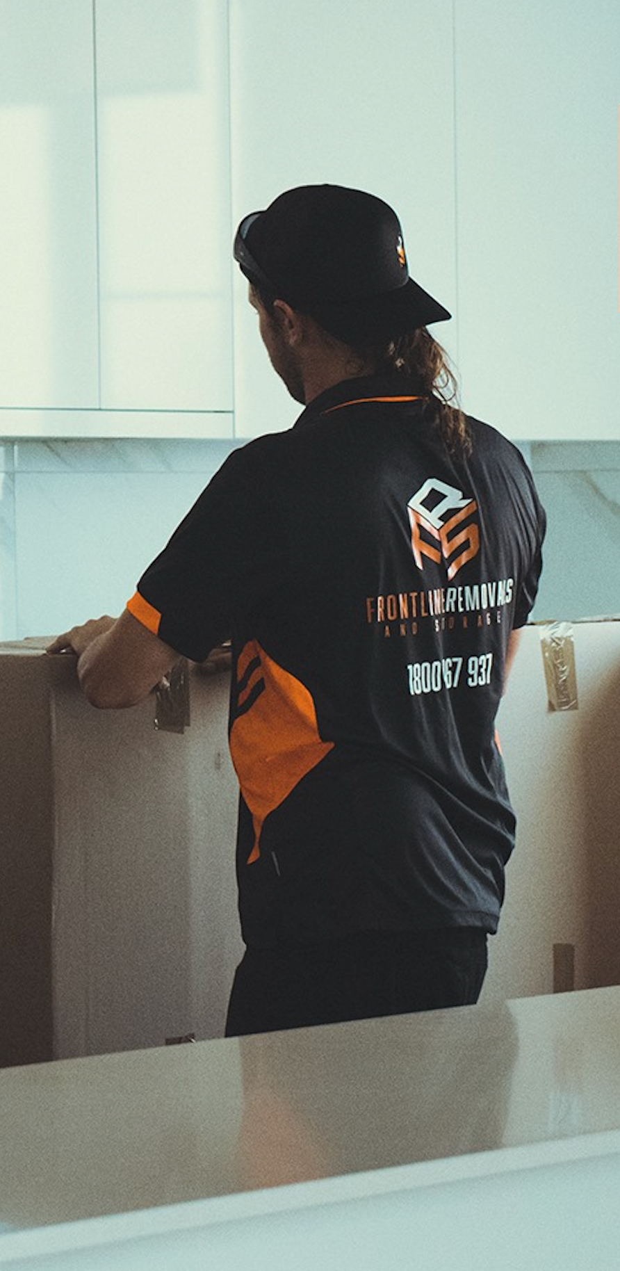 A Woman Is Wrapping A Cardboard Box With Tape — Frontline Removals And Storage in Forster, NSW