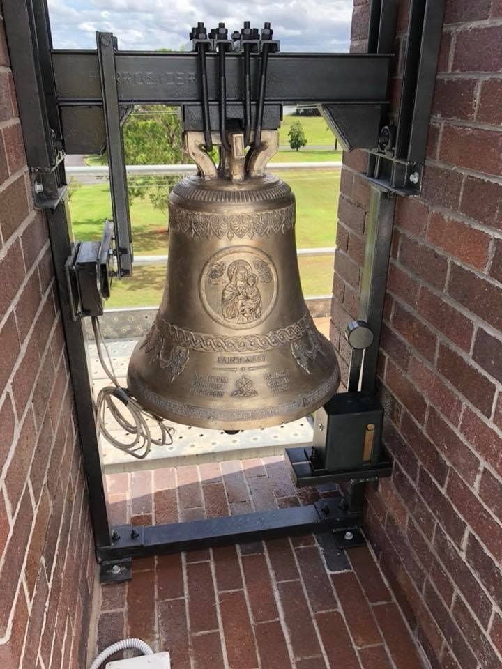 A Large Bell is Sitting on Top of a Brick Wall — Burke Metal Fabrication In Taree, NSW