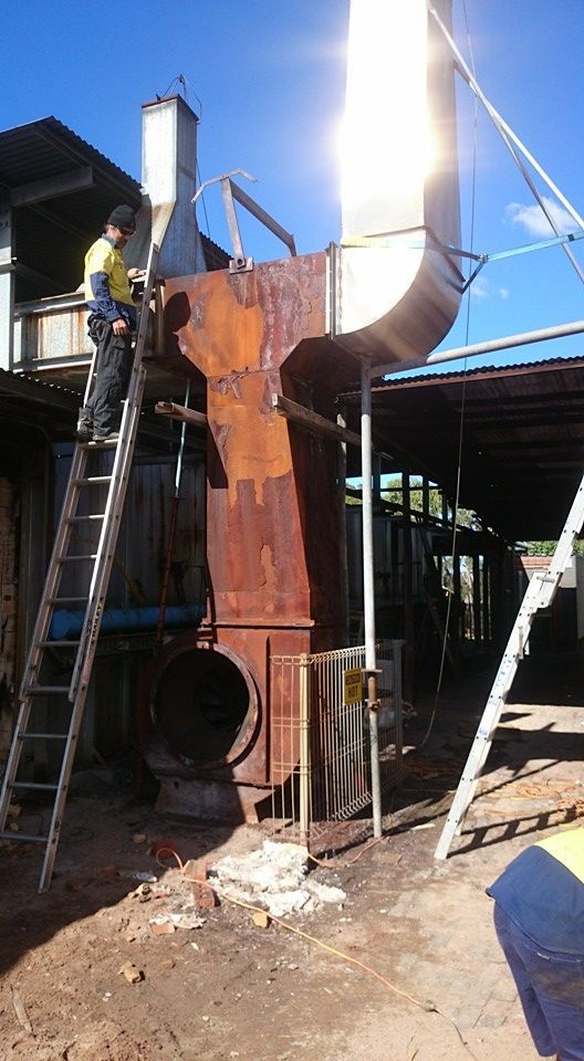 A Man is Working on a Steel Structure Outside — Burke Metal Fabrication In Taree, NSW