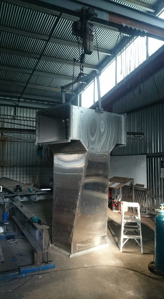 A Large Metal Structure is Sitting in a Large Shed — Burke Metal Fabrication In Taree, NSW