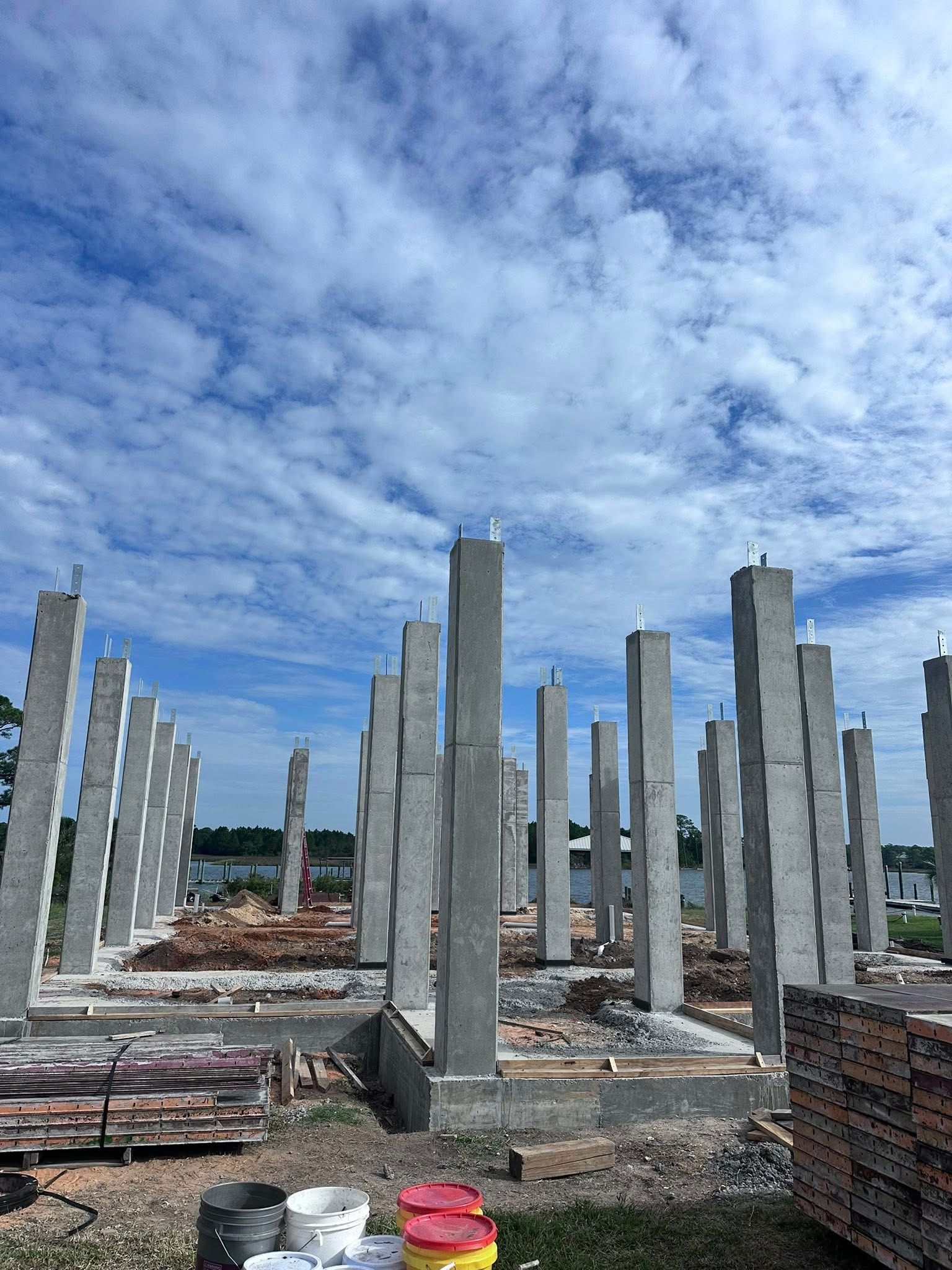 Concrete building columns on a construction site under a cloudy sky
