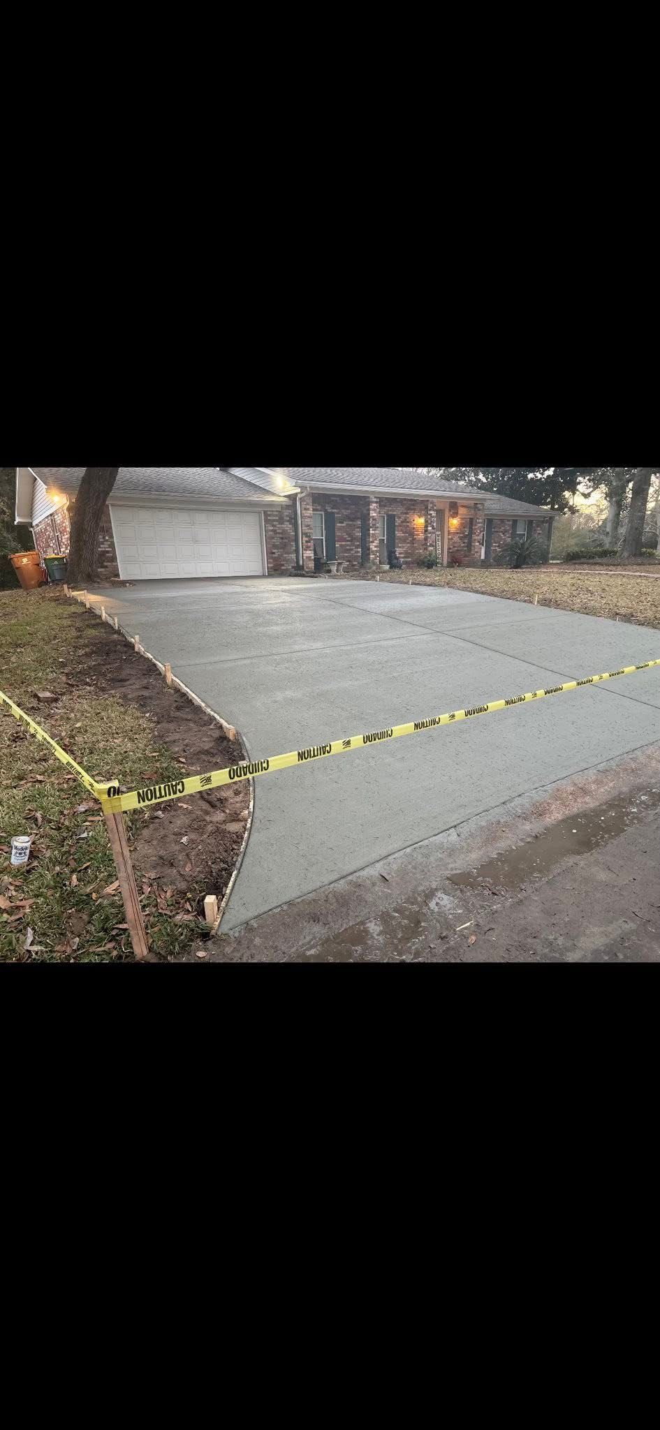 Yellow caution tape blocking a wet driveway in front of a house and garage