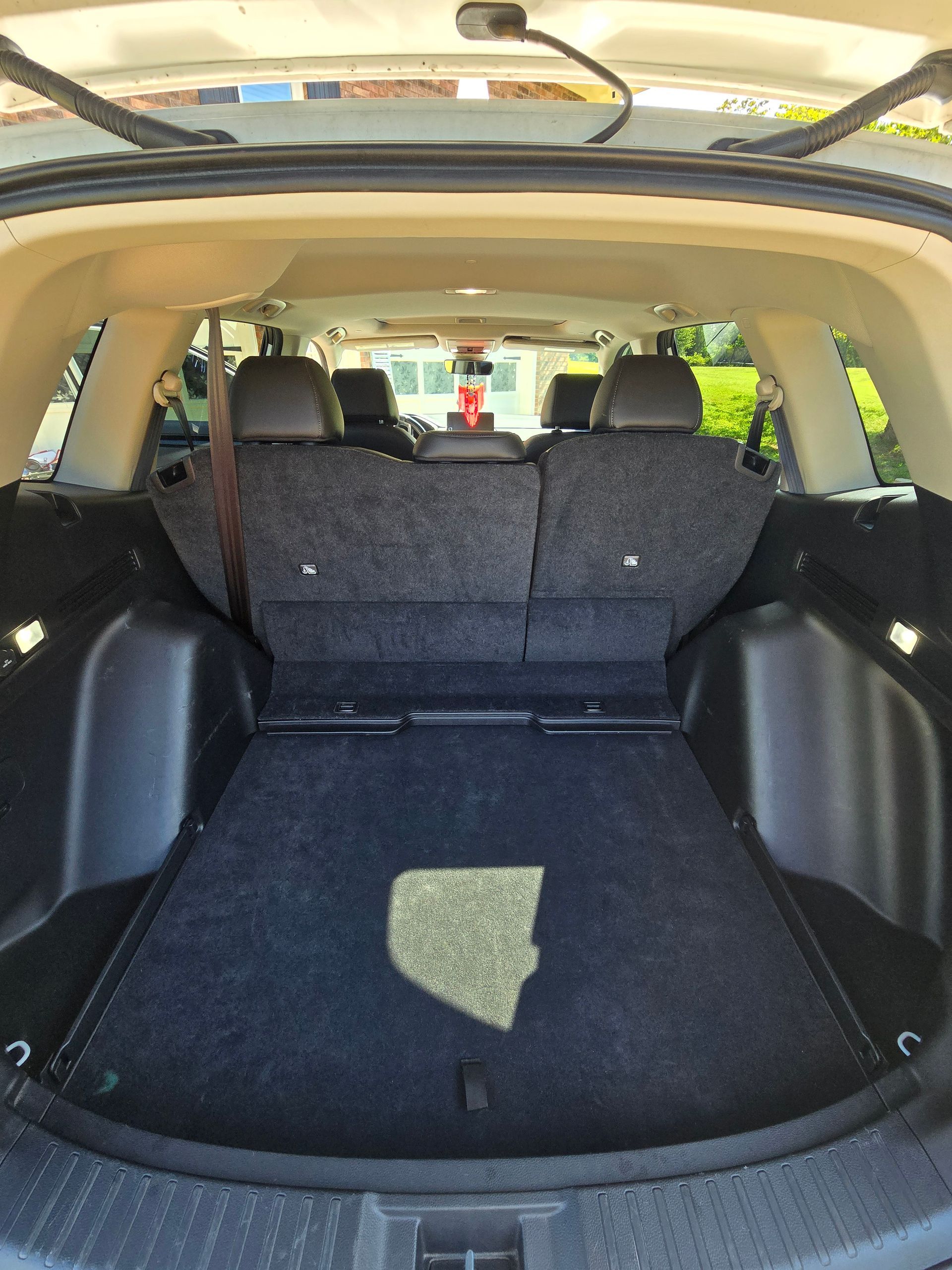 The open cargo area of a dark-interior SUV, showing a folded rear seat and a rectangular floor patch.