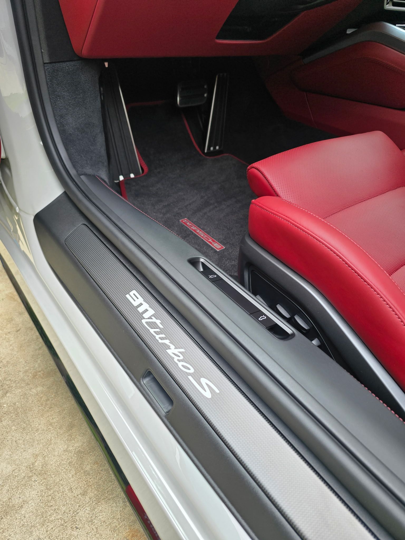 Interior of a car with a black carbon-fiber door sill plate inscribed with 