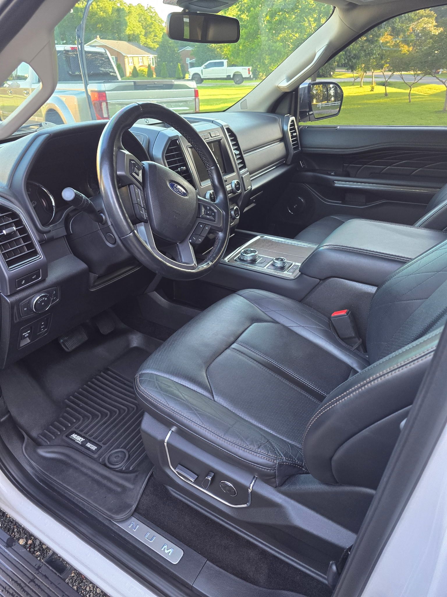 Interior view of a modern truck featuring a leather driver's seat, steering wheel, and console.