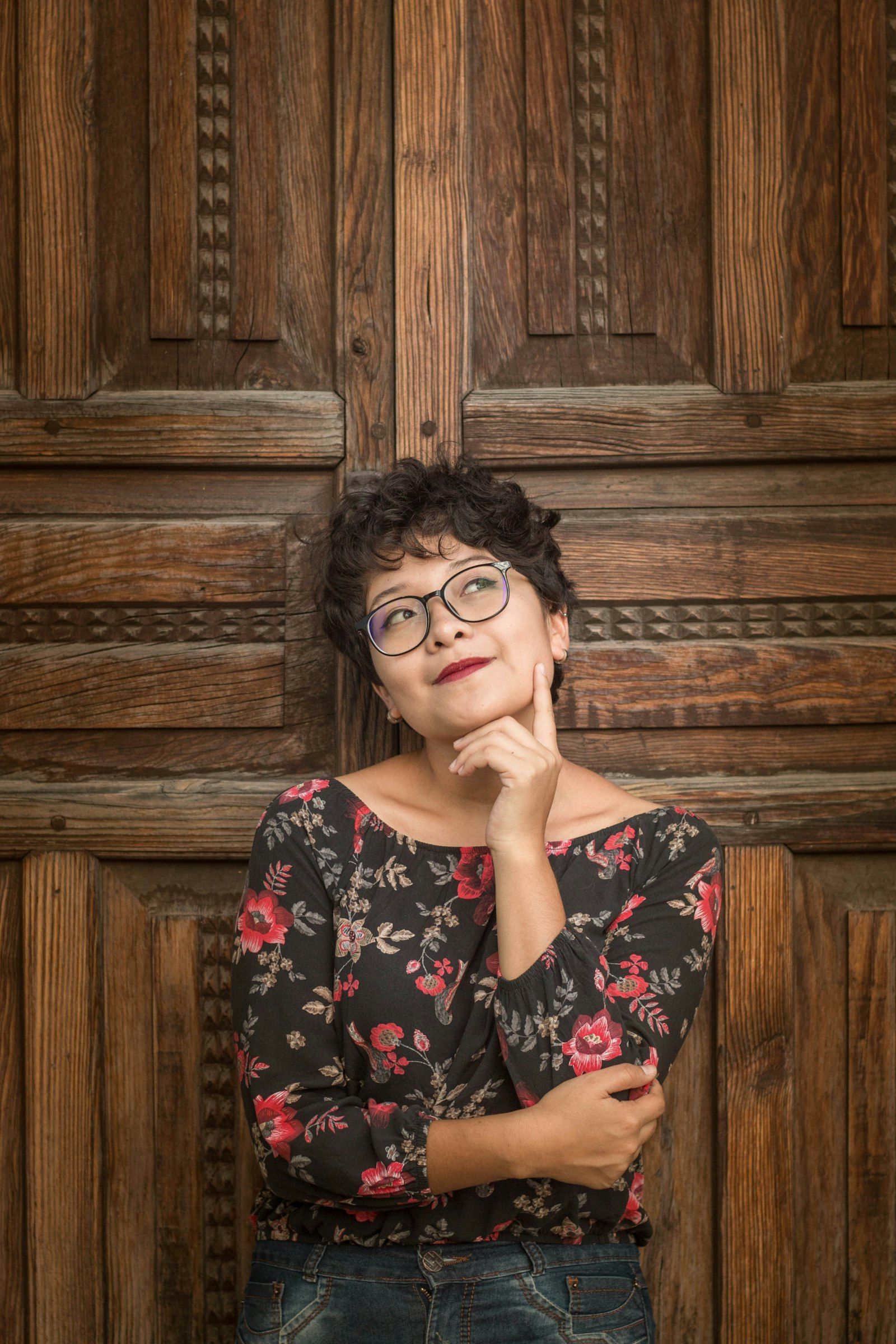 Woman leaning against a door, looking calm