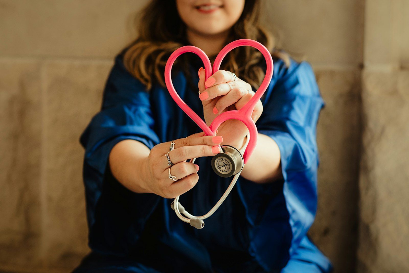 Medical professional holding a heart-shaped stethoscope