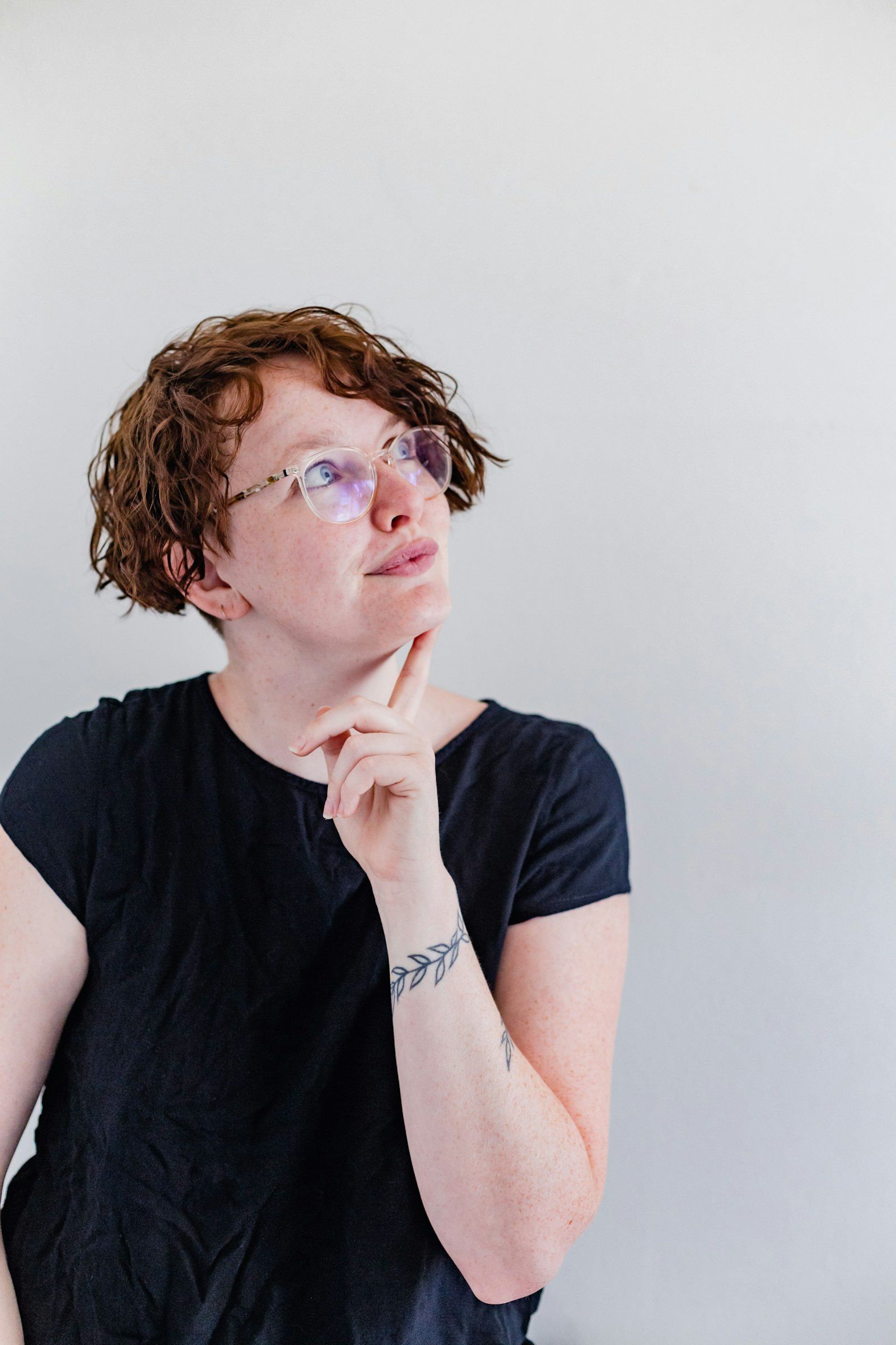 Woman with glasses looking thoughtful