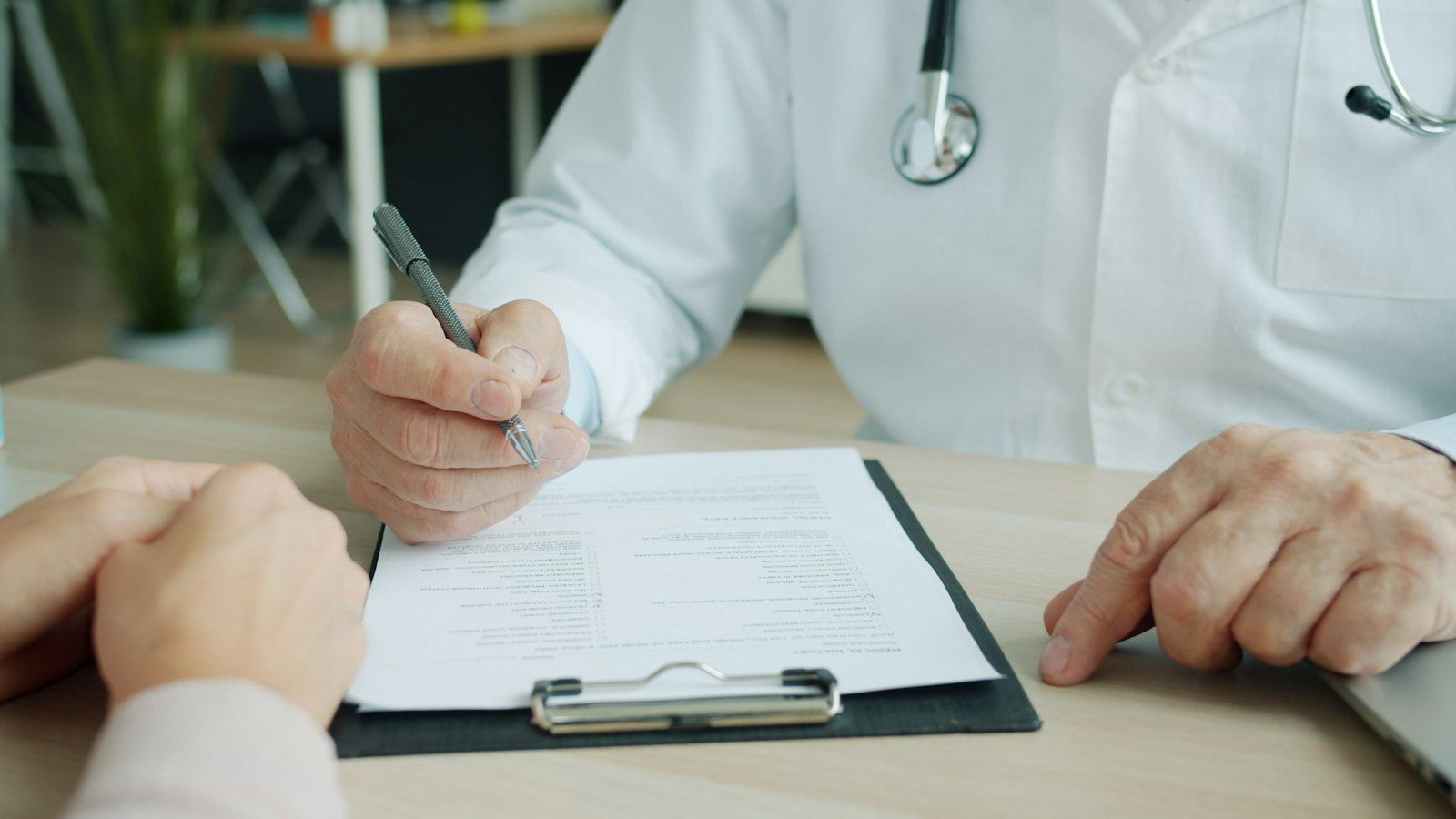 Doctor writing in a patient chart