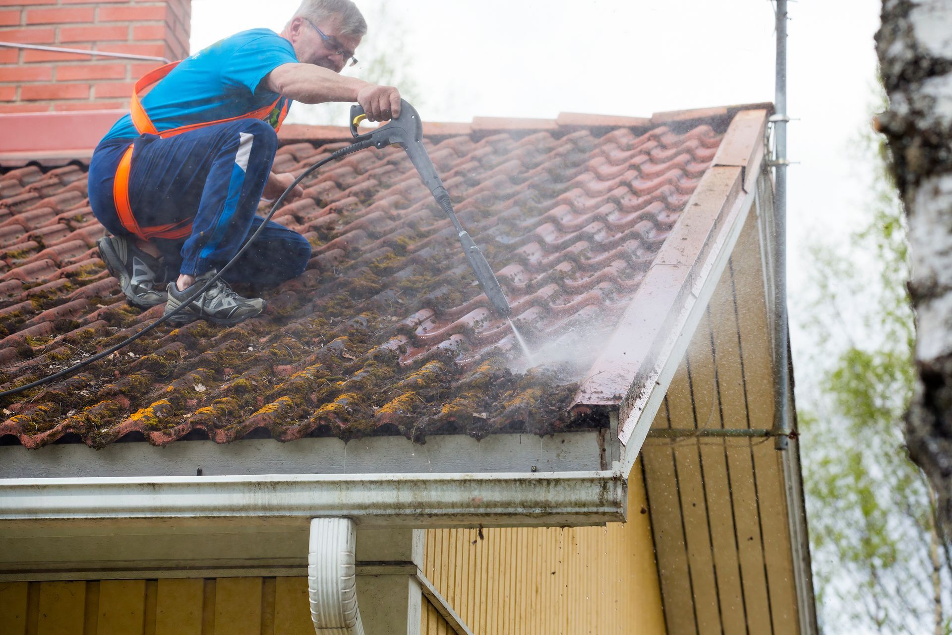 A man is cleaning a roof.
