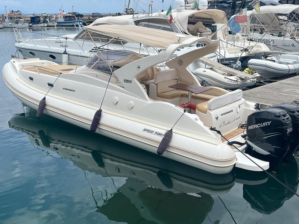 Una barca bianca con un motore Mercury è attraccata in un porto turistico.