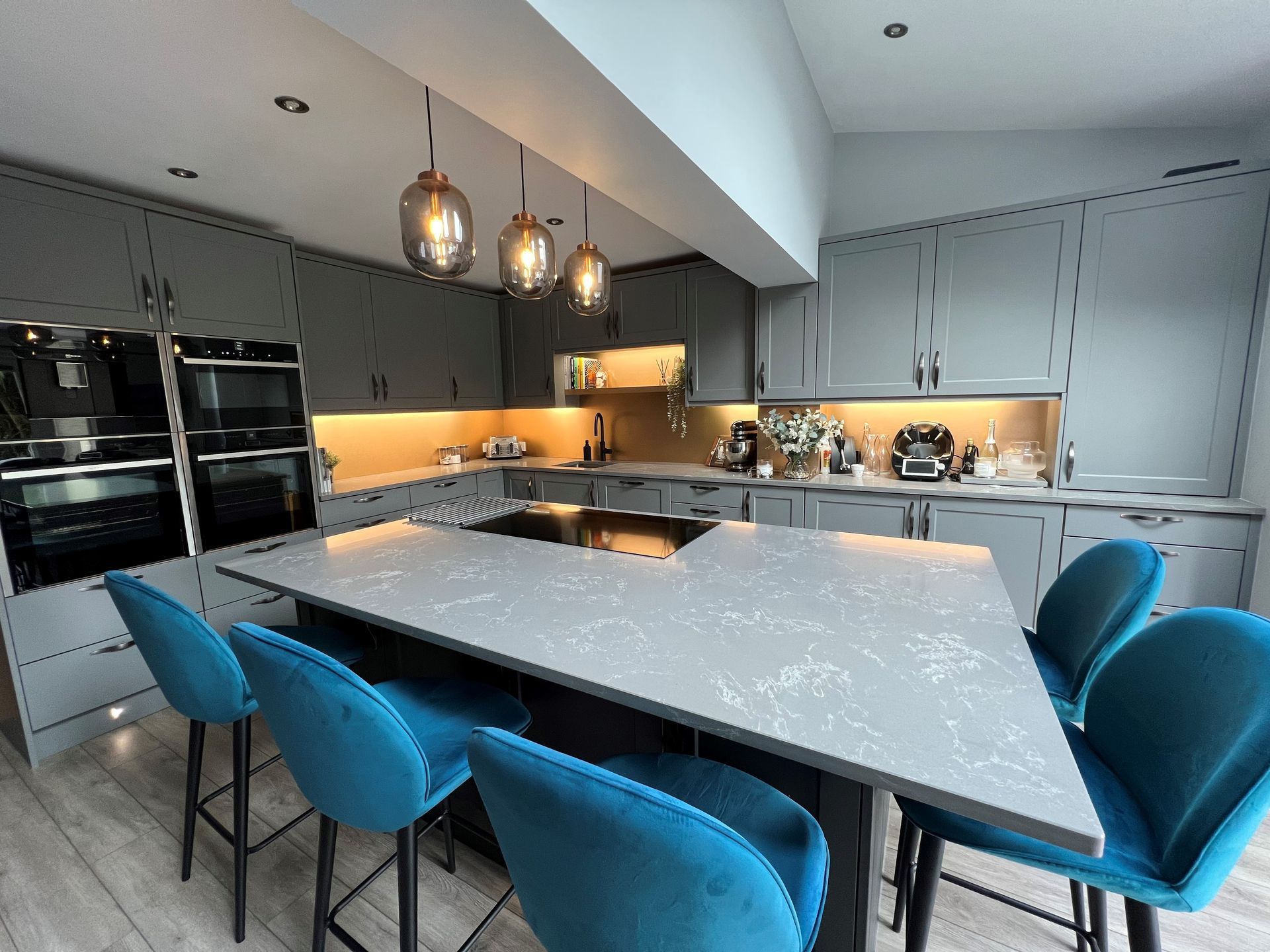A kitchen with a large table and blue chairs