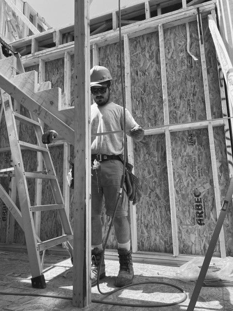 A black and white photo of a construction worker in a building under construction.