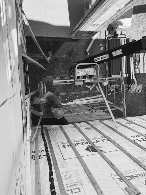 A black and white photo of a construction site with a crane.