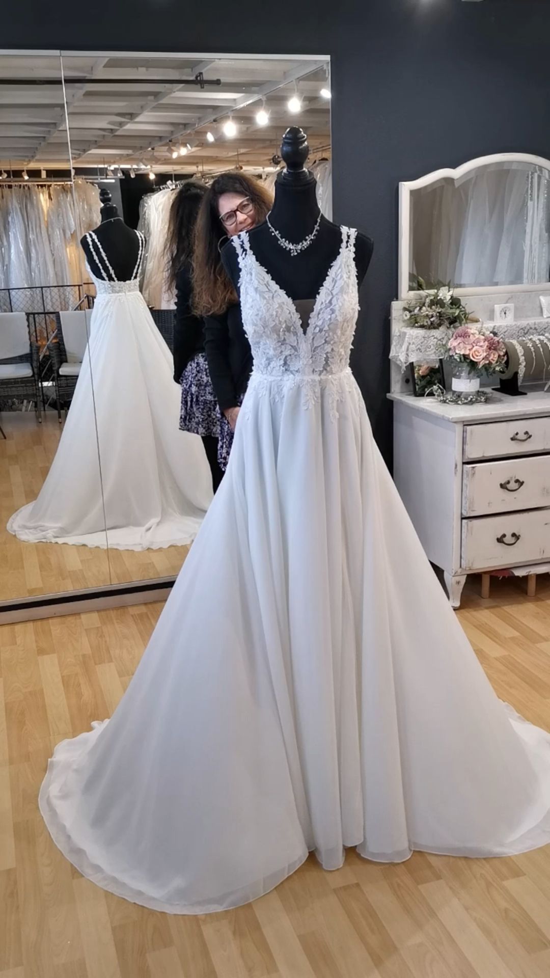 Weißes Spitzenhochzeitskleid mit schwarzen Tüllakzenten an einer Schaufensterpuppe in einer Brautboutique
