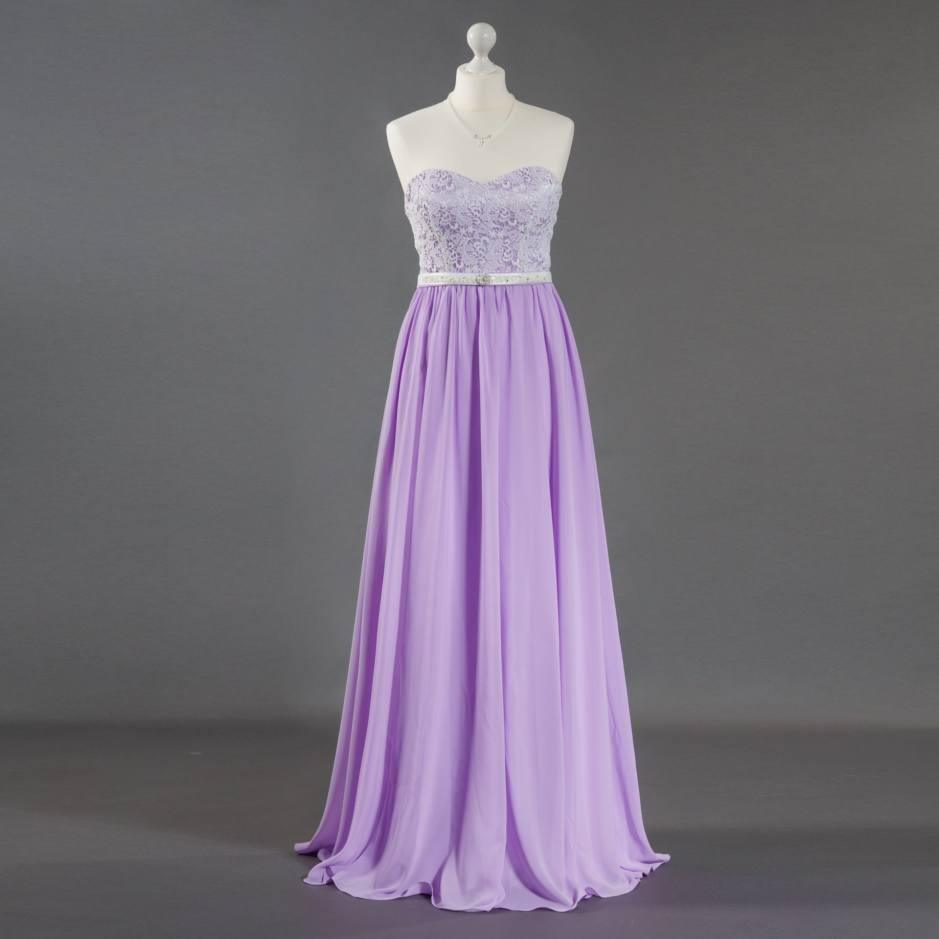 Lavendelfarbenes, trägerloses Chiffon-Abendkleid auf einer Schaufensterpuppe vor grauem Hintergrund