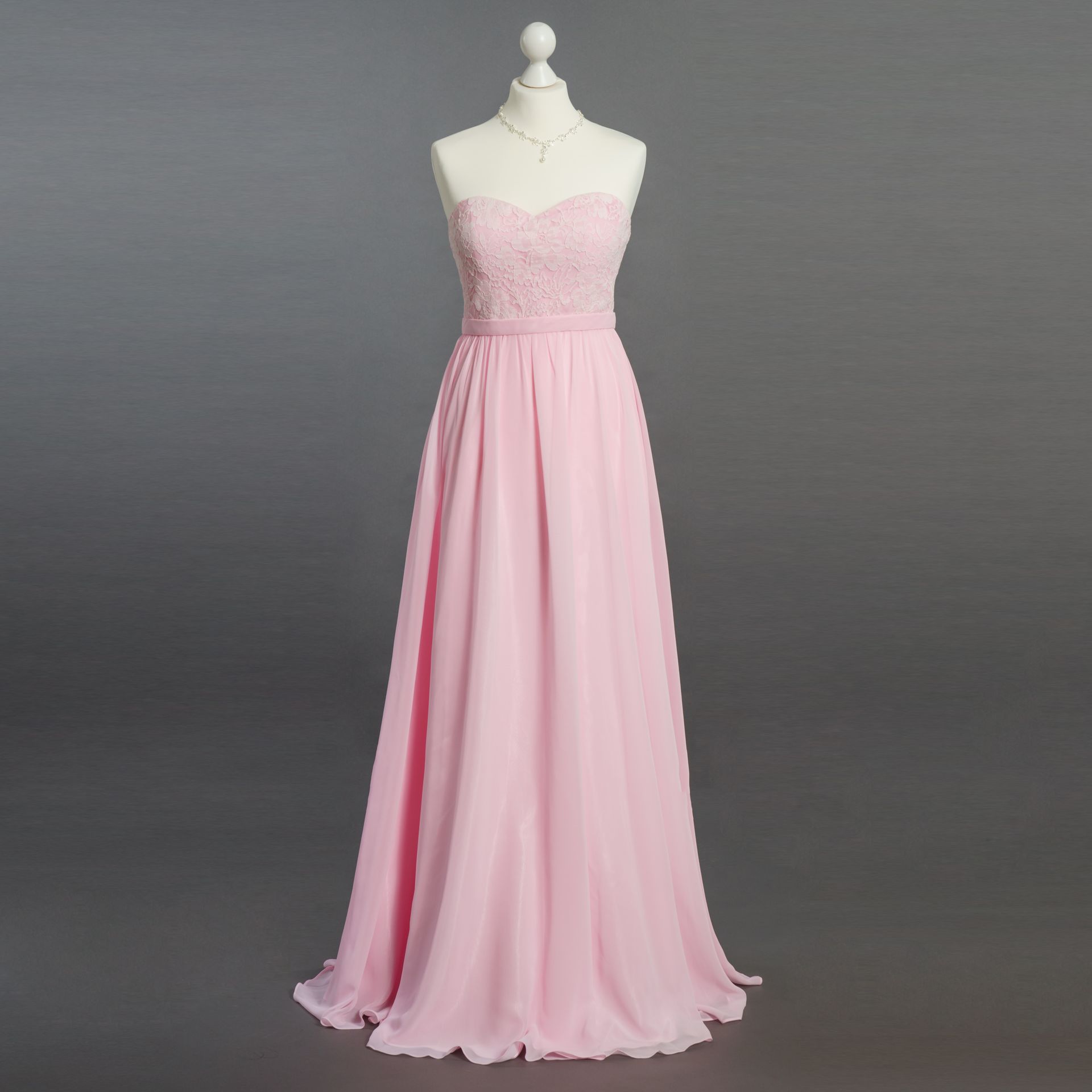 Rosa, trägerloses, bodenlanges Kleid an einer Schaufensterpuppe vor grauem Hintergrund
