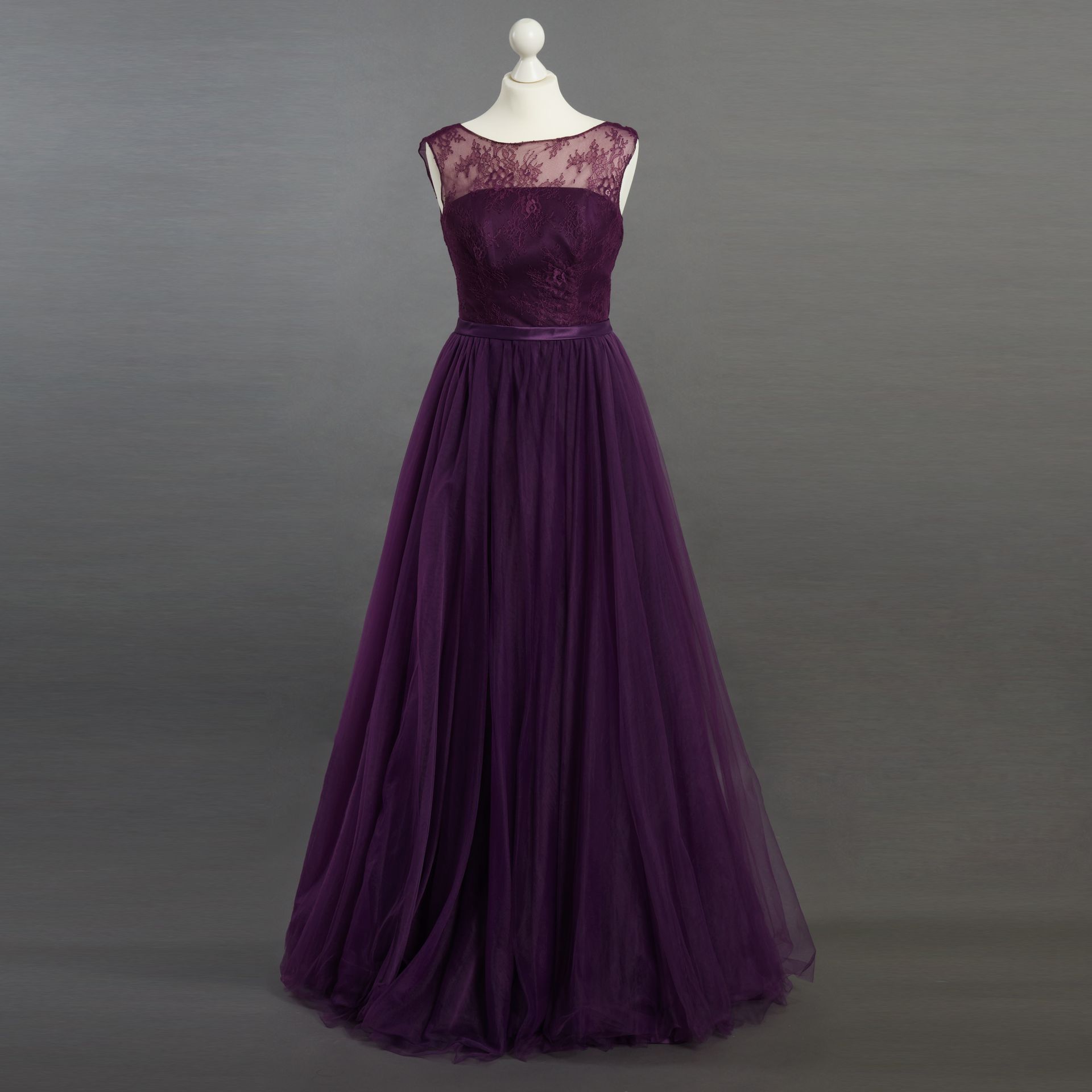 Lila trägerloses Abendkleid an einer Schneiderpuppe, mit voluminösem Tüllrock und Spitzenoberteil.