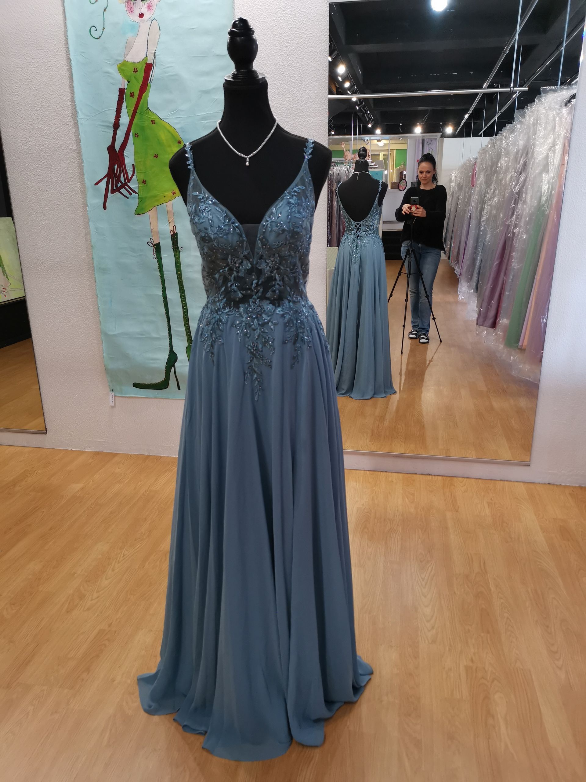 Blaues Abendkleid, ausgestellt an einer Schaufensterpuppe in einem Abendmodegeschäft.