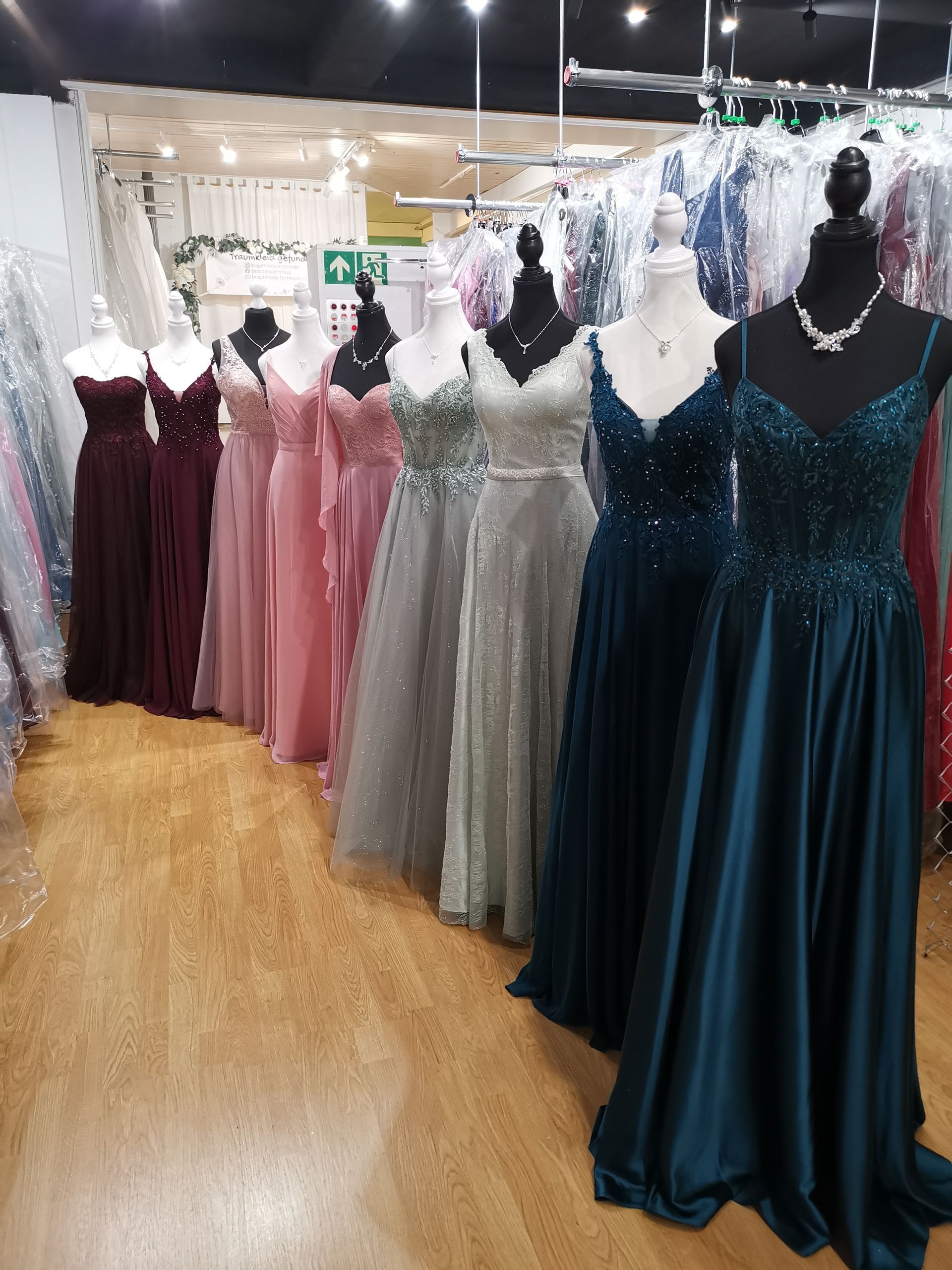 In einem Boutique-Showroom wurden Kleiderständer mit festlichen Kleidern in verschiedenen Farben ausgestellt.