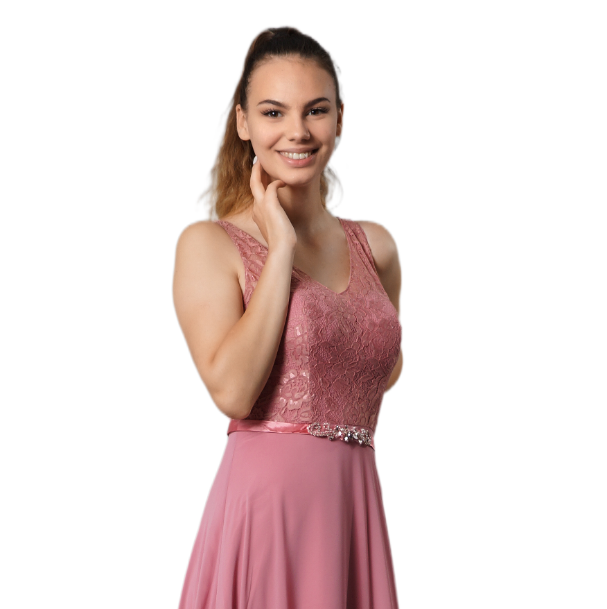 Eine lächelnde Frau in einem rosa Kleid posiert vor einem weißen Hintergrund, die Hand in der Nähe ihres Gesichts.