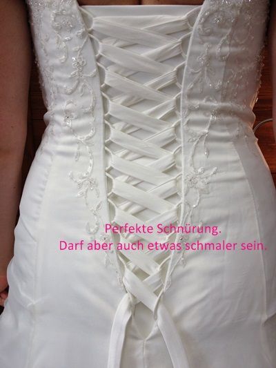 Weißes Brautkleid mit Korsettrücken und rosafarbenem deutschen Textaufdruck.