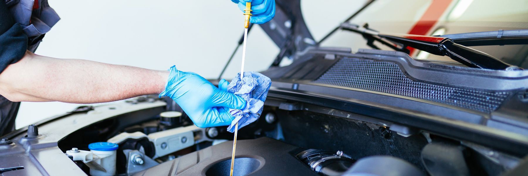A man is working on a car engine with a wrench.