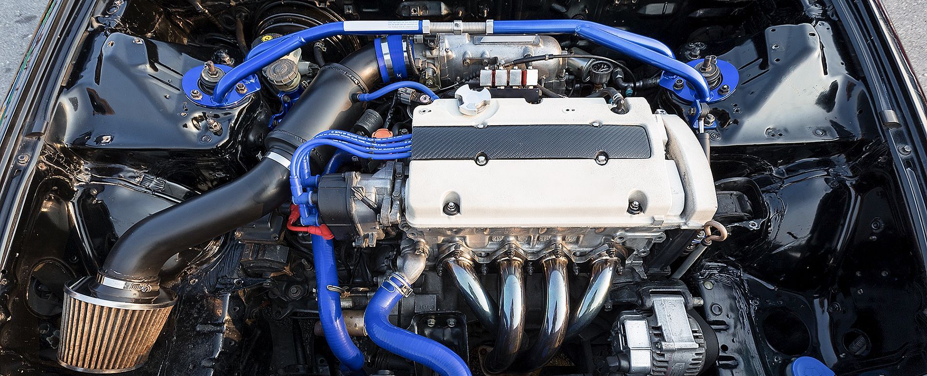 A close up of a car engine with blue hoses