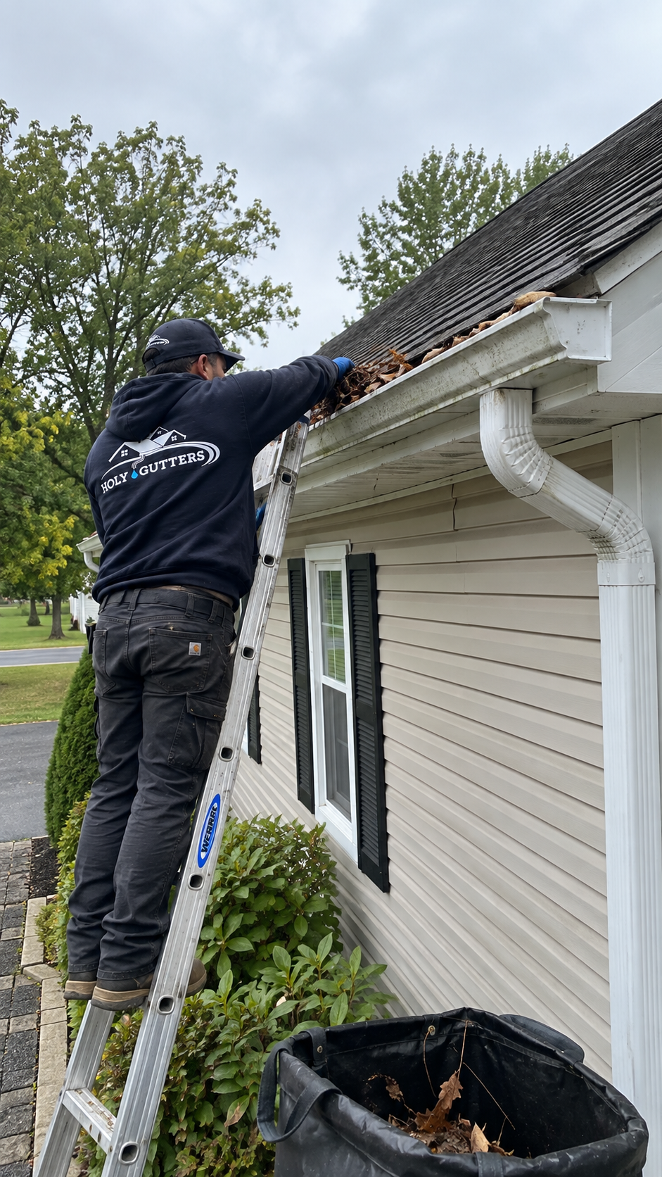 Roofing crew installing shingles on a house roof with stacked materials nearby