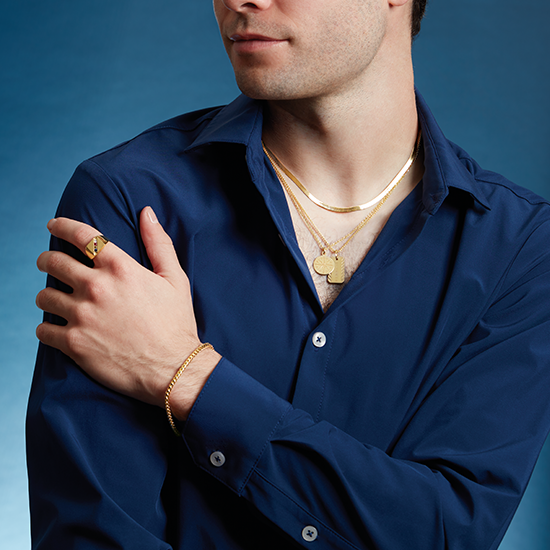 A man wearing a blue shirt and gold jewelry