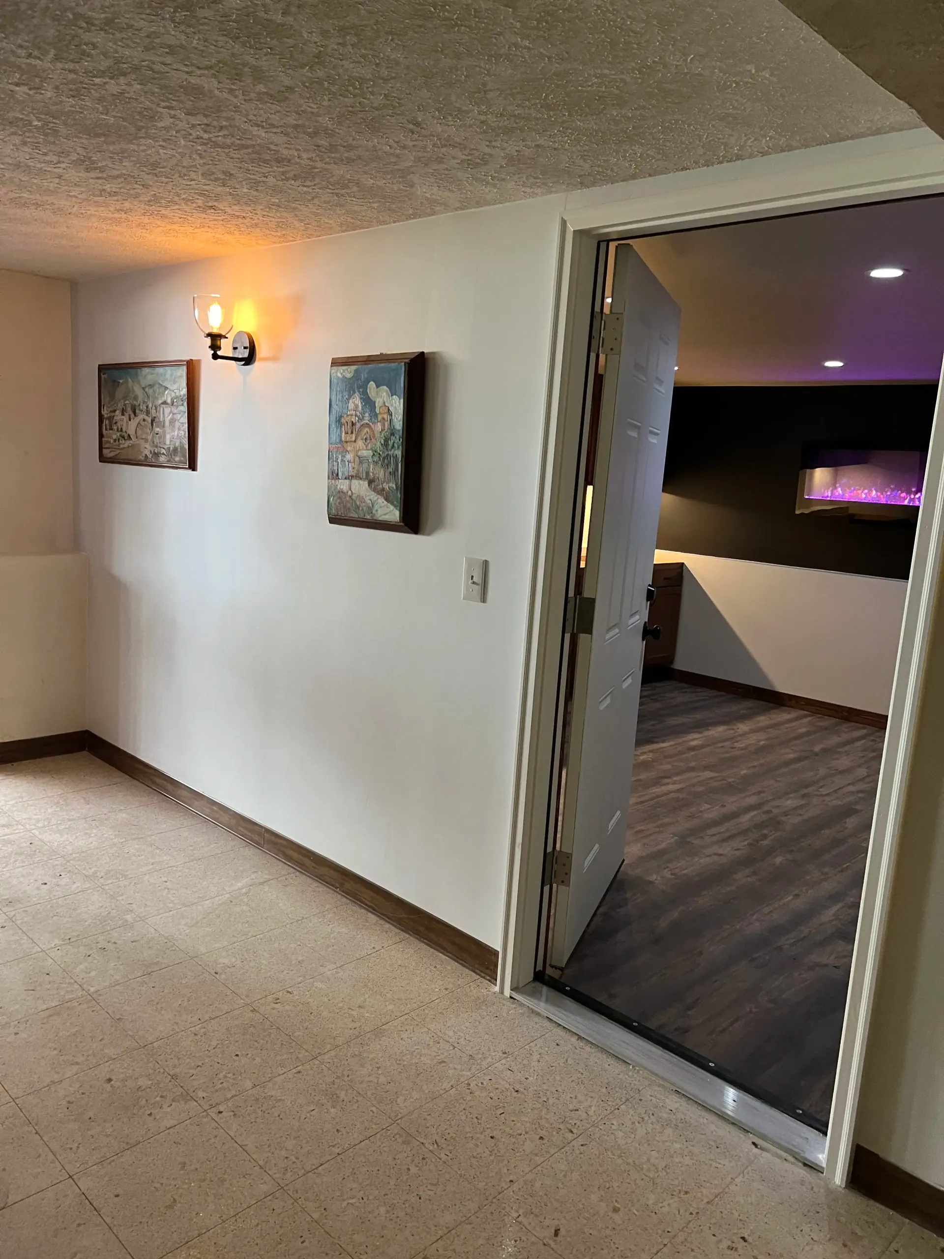 An unfinished garage interior with bare, joint-compounded drywall walls and a concrete floor.